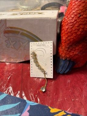 This item is a Pastel Collection rhinestone ear cuff with a chain.